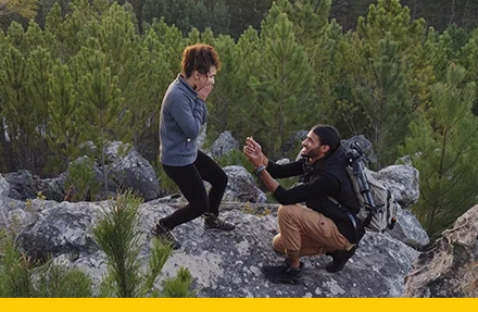A person on one knee proposes to their partner